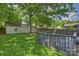 Green backyard with a gray wooden deck and a large tree, providing a serene outdoor space at 2015 Club Rd, Charlotte, NC 28205