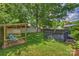 Lush backyard featuring a wooden deck, cozy seating area, and mature trees offering shade and privacy at 2015 Club Rd, Charlotte, NC 28205