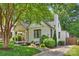 Charming white brick home featuring a quaint front porch and lush landscaping at 2015 Club Rd, Charlotte, NC 28205