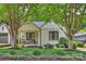 Charming white brick home featuring a quaint front porch and lush landscaping at 2015 Club Rd, Charlotte, NC 28205