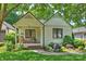 Charming brick home featuring a quaint front porch, lush landscaping, and classic architectural details at 2015 Club Rd, Charlotte, NC 28205