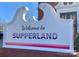 A sign that reads 'Welcome to Supperland' in a stylized font at 2015 Club Rd, Charlotte, NC 28205