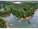 Aerial view showcases a waterfront property with private boat docks surrounded by lush greenery, offering direct lake access at 221 Silvercliff Dr, Mount Holly, NC 28120