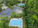 Aerial view of the community pool, tennis courts, and parking, surrounded by mature trees, promising an active lifestyle at 221 Silvercliff Dr, Mount Holly, NC 28120