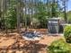 Serene backyard featuring a fire pit, deck, and lush greenery at 221 Silvercliff Dr, Mount Holly, NC 28120