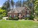 Charming brick two-story home with well-manicured lawn and mature landscaping, exuding classic elegance at 221 Silvercliff Dr, Mount Holly, NC 28120