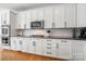 Close-up shot of modern kitchen with custom white cabinetry, subway tile backsplash, and granite countertops at 221 Silvercliff Dr, Mount Holly, NC 28120