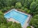 Aerial view of a large, refreshing pool surrounded by lounge chairs and lush greenery, ideal for summer relaxation at 221 Silvercliff Dr, Mount Holly, NC 28120