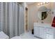 Bathroom featuring a shower with striped curtain, white vanity, and a round mirror at 231 Stockwood Dr, Stanley, NC 28164