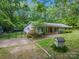 View of home showing stone accents, red shutters, basketball court, landscaping and storage shed at 231 Stockwood Dr, Stanley, NC 28164