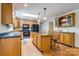 Well-lit kitchen featuring wood cabinets, black appliances, and a convenient center island at 231 Stockwood Dr, Stanley, NC 28164