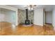 Cozy living room with hardwood floors, stone accent wall, and a wood-burning stove at 231 Stockwood Dr, Stanley, NC 28164
