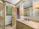 Bright bathroom featuring stylish wallpaper, framed mirror, and elegant vanity with a light-colored countertop at 2501 Richardson Dr, Charlotte, NC 28211