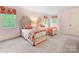 Bright bedroom featuring twin beds with decorative linens and matching valances, illuminated by natural light at 2501 Richardson Dr, Charlotte, NC 28211