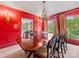Formal dining room with red walls, chandelier lighting, and large wooden table at 2501 Richardson Dr, Charlotte, NC 28211