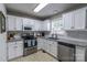 Well-lit kitchen features white cabinets, stainless steel appliances, and granite countertops at 2551 Glenwood St, Kannapolis, NC 28083