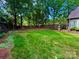 Lush, green backyard surrounded by mature trees and a wooden fence, offering privacy and ample space at 2600 Kirkholm Dr, Matthews, NC 28105