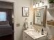 Well-lit bathroom featuring a marble vanity, decorative mirror, and framed botanical artwork at 2600 Kirkholm Dr, Matthews, NC 28105