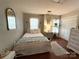 Cozy bedroom with a white iron bed, patterned bedding, hardwood floors, and bright natural light at 2600 Kirkholm Dr, Matthews, NC 28105