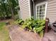 Close-up of the home's exterior with well-maintained landscaping and lush flower beds along the walkway and deck at 2600 Kirkholm Dr, Matthews, NC 28105