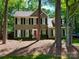 Charming two-story home with neutral siding, black shutters, and a vibrant red front door, nestled among mature trees at 2600 Kirkholm Dr, Matthews, NC 28105