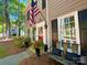 Inviting front porch with a red door, bench seating, potted plants, and an American flag displayed at 2600 Kirkholm Dr, Matthews, NC 28105
