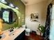 Charming half bathroom featuring an ornate mirror, unique wall decor, and a sleek vanity at 2600 Kirkholm Dr, Matthews, NC 28105