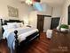 Bright bedroom with vaulted ceilings, a dark bed frame, hardwood floors, and a barn door at 2600 Kirkholm Dr, Matthews, NC 28105