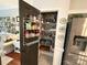 Walk-in pantry with shelving, door storage, and decorative wallpaper for organized storage at 2600 Kirkholm Dr, Matthews, NC 28105