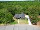 Aerial view of a home nestled amongst mature trees, showcasing its secluded location and long driveway at 2694 Woodcrest Sw Dr, Concord, NC 28027