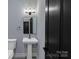 Bathroom with a pedestal sink, modern fixtures, and toilet at 2694 Woodcrest Sw Dr, Concord, NC 28027