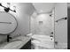 Bathroom with stylish round mirror, tiled shower/tub, and granite vanity at 2694 Woodcrest Sw Dr, Concord, NC 28027