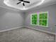 Bedroom featuring tray ceilings, carpet, large windows offering plenty of natural light at 2694 Woodcrest Sw Dr, Concord, NC 28027
