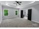 Spacious bedroom featuring tray ceilings, carpet, and large windows offering plenty of natural light at 2694 Woodcrest Sw Dr, Concord, NC 28027