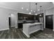 Modern kitchen with granite countertops, stainless steel appliances, dark wood cabinets, and a central island at 2694 Woodcrest Sw Dr, Concord, NC 28027