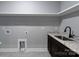 Well-lit laundry room with granite countertops, sink, and utility connections at 2694 Woodcrest Sw Dr, Concord, NC 28027