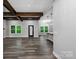 Spacious living room features wood flooring, exposed beams, and a doorway to the kitchen and dining area at 2694 Woodcrest Sw Dr, Concord, NC 28027