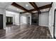 Open-concept living room with stone fireplace, wood beams, hardwood flooring, and archways to other rooms at 2694 Woodcrest Sw Dr, Concord, NC 28027