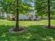 Spacious backyard with lush lawn and home exterior viewed through trees at 270 Conifer Way, Shelby, NC 28150