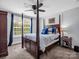 Well-lit primary bedroom with four-poster bed, ceiling fan, and large windows offering plenty of natural light at 270 Conifer Way, Shelby, NC 28150