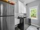 A bright laundry room with stainless steel appliances and white cabinets at 270 Conifer Way, Shelby, NC 28150