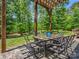 Outdoor patio with dining furniture set on stone pavers and mature trees at 270 Conifer Way, Shelby, NC 28150