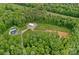 Aerial view of property with a house, outbuilding, pool, and cleared land surrounded by lush trees at 270 Worthington Dr, Mt Ulla, NC 28125