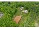 Serene aerial shot featuring a house with pool and outbuilding surrounded by lush greenery and cleared acreage at 270 Worthington Dr, Mt Ulla, NC 28125