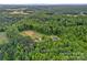 Expansive aerial view of wooded acreage featuring a charming home and cleared land ready for your vision at 270 Worthington Dr, Mt Ulla, NC 28125