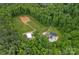 Aerial view showcases a home with pool, outbuilding, and cleared land surrounded by lush greenery at 270 Worthington Dr, Mt Ulla, NC 28125