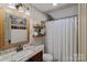 Bathroom featuring single sink with granite countertop, shelving, and shower with curtain at 270 Worthington Dr, Mt Ulla, NC 28125