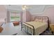 Charming bedroom with a metal frame bed, soft natural light, and soothing pastel pink walls at 270 Worthington Dr, Mt Ulla, NC 28125