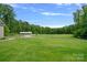 Exterior with lush green grass surrounding a metal building and bordering a dense tree line at 270 Worthington Dr, Mt Ulla, NC 28125