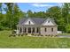 Charming brick home featuring a covered front porch and lush green lawn with mature trees at 270 Worthington Dr, Mt Ulla, NC 28125